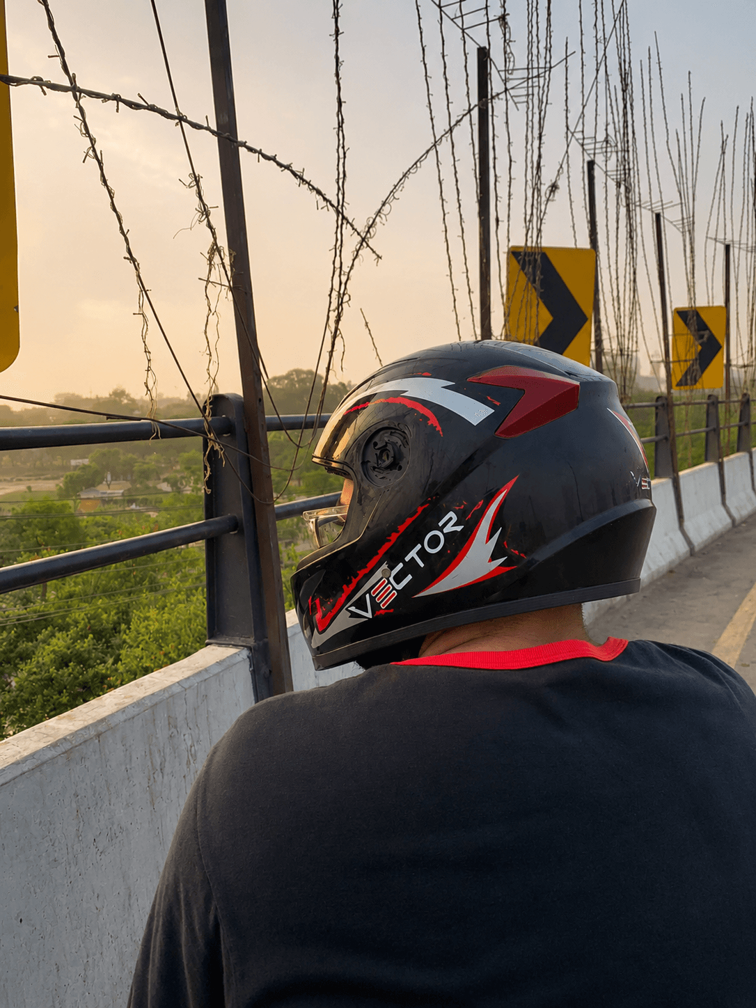 Vector Red Lightning helmet on a rider near a bridge at golden hour
