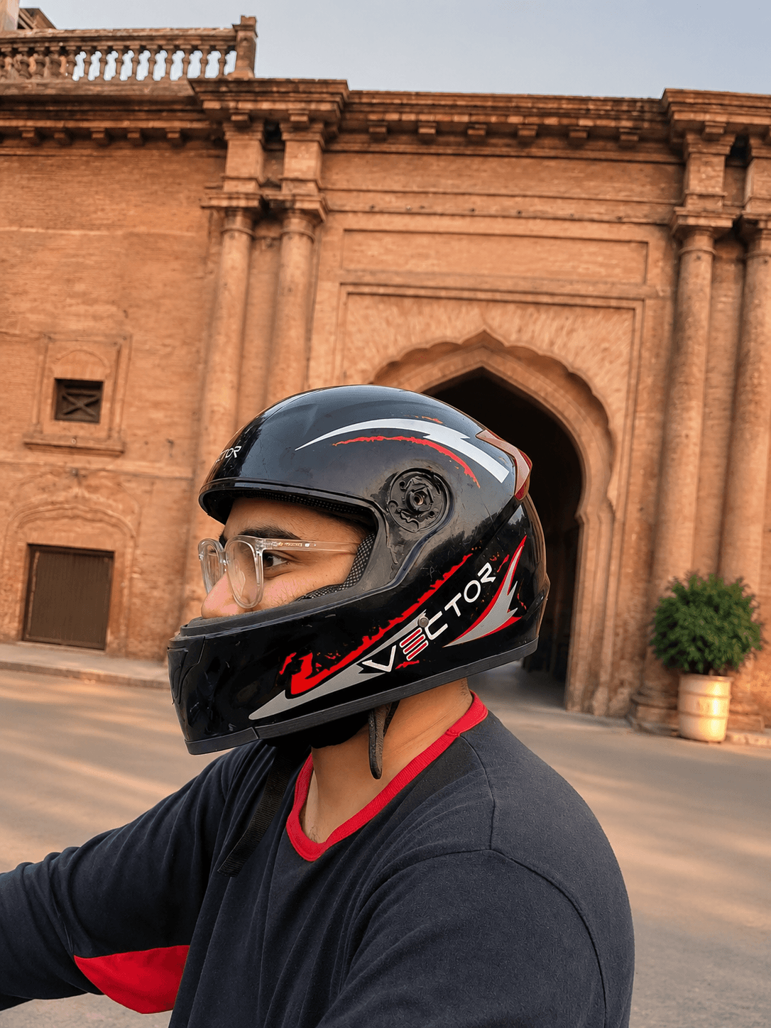 Vector Red Lightning helmet side profile near a heritage building